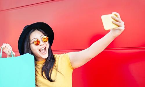 young asian woman taking selfie with shopping bags