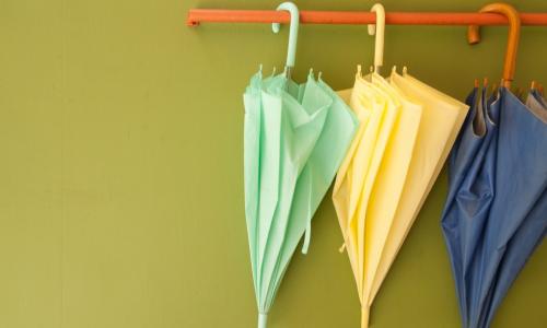 three umbrellas hanging on a bar