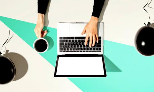 person using laptop with black balloons