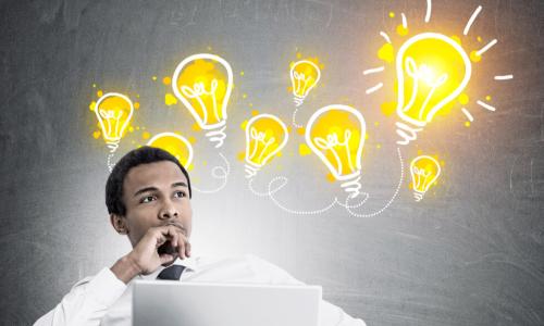 Black businessman sitting in a chair with light bulbs