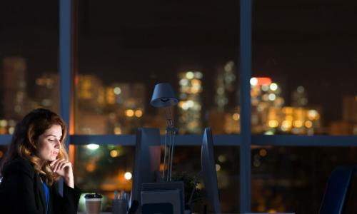 businesswoman leader works alone in dark office at night