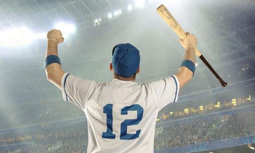 number 12 baseball player holding baseball bat pumps fists in victory in front of stadium crowd 