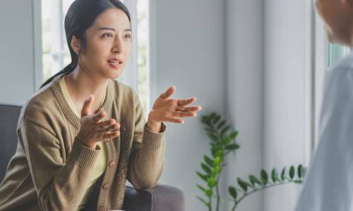 stressed female employee talks to well-being coach in office burnout clinic