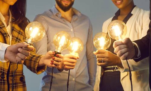 young multiethnic business team holding light bulbs