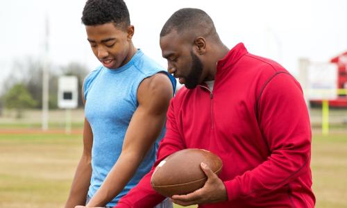 Football coach advising young athlete