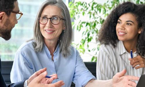 senior female executive sponsors younger BIPOC exec in a meeting