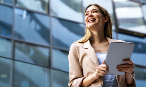 smiling business woman in front of building 