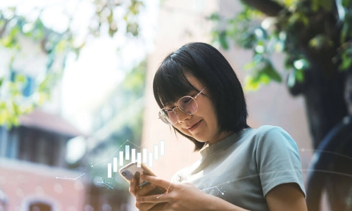 smiling young woman uses personal finance app on smartphone 