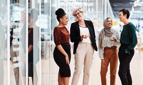 Group of businesswomen of diverse ages and ethnicities chat in the office 